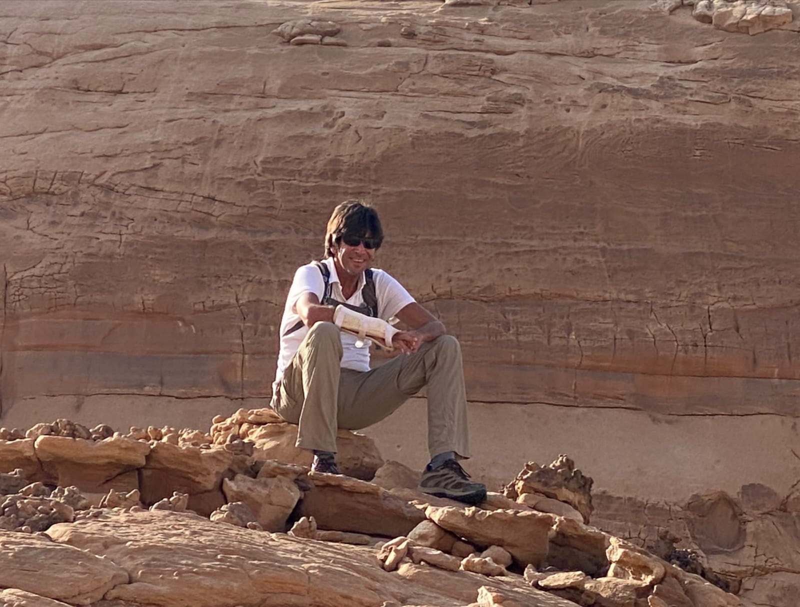 Alain assis contre un rocher de grès rouge, Égypte